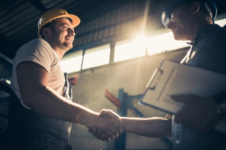 Workers greeting with handshake indoors.