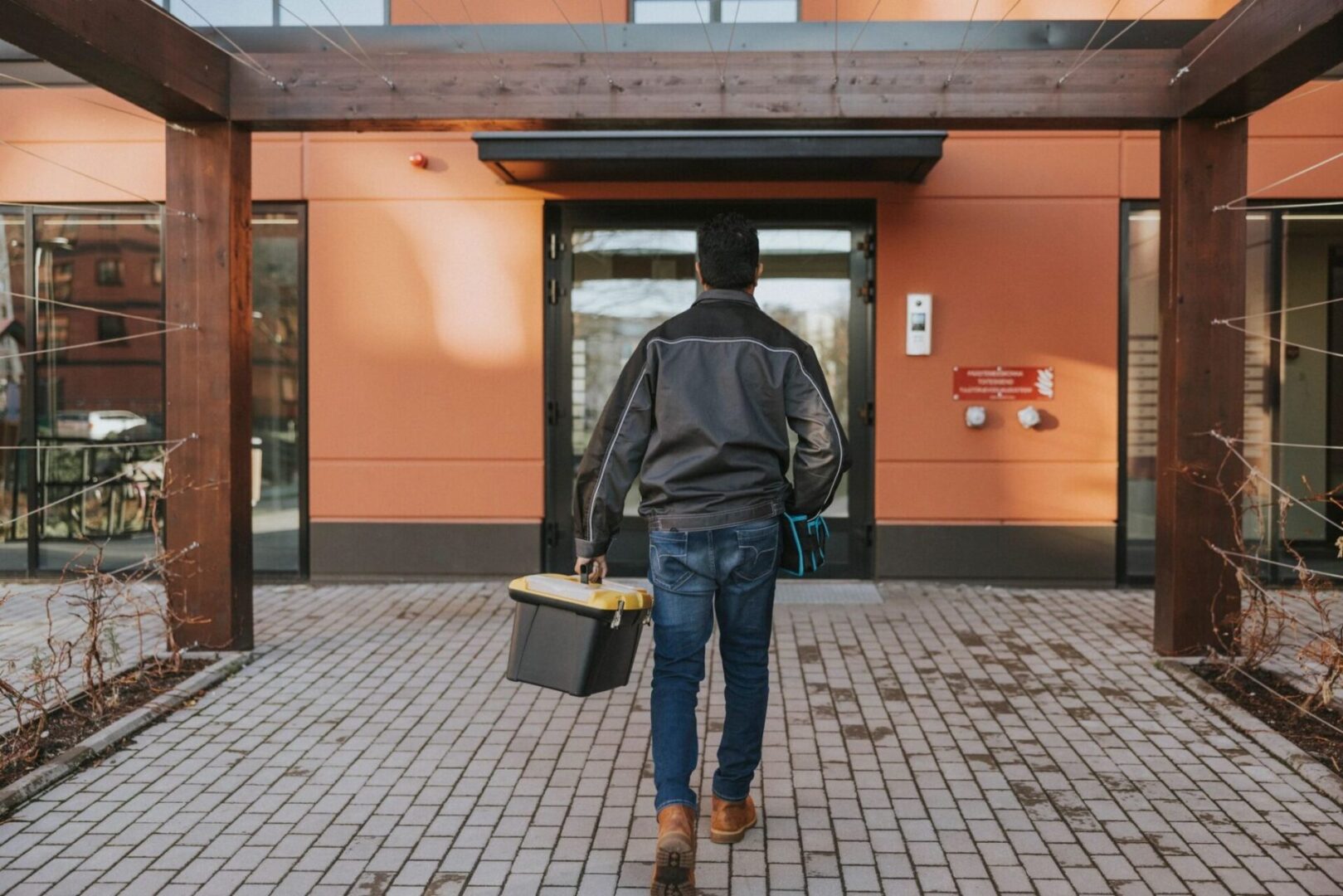 Individual carrying toolbox on pathway