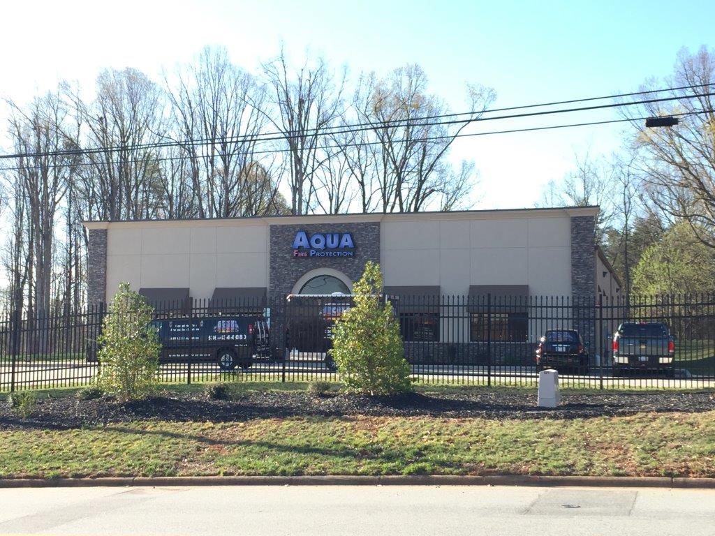 Exterior view of a modern building with a sign reading 'Aqua'.